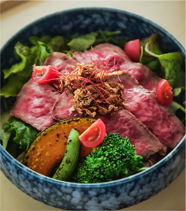 A bowl of rice topped with seared local roast beef